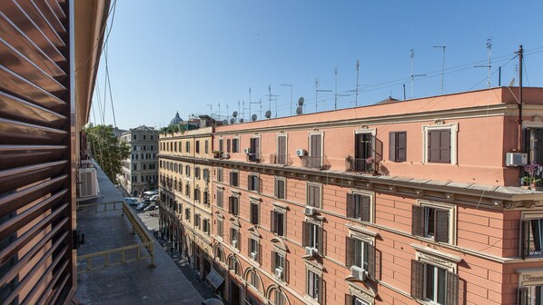 A row of traditional buildings with uniform window shutters and balconies, typical of historic European architecture.