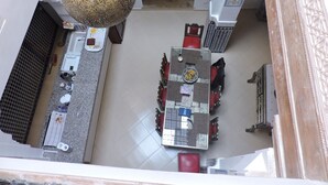 Un comedor con una mesa grande, sillas rojas y un farol colgante.