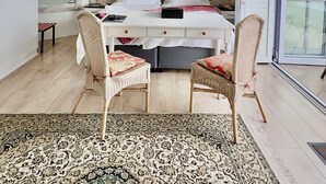Un dormitori modern amb un llit, dues cadires, una catifa i vistes a la ciutat.
