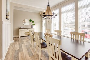 Enjoy meals in this elegant dining area with a wooden table, comfortable chairs, and a large mirror.