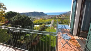 Un balcón con vistas a un paisaje montañoso y al mar.