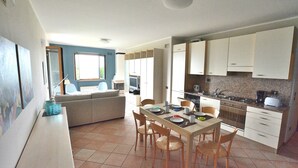 Una cocina moderna con una mesa de comedor, sillas y electrodomésticos esenciales.