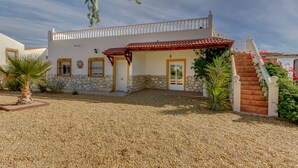 A two-story building with a stone facade, a red-tiled roof, and a white balcony. - Villa Damara, luxury apartment Oliva, the place to relax! (Albox)