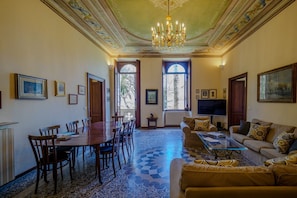 Una habitación amplia con una mesa de comedor, sillas, un sofá y una televisión.