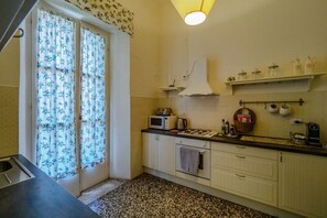 Una cocina con microondas, estufa y armarios.