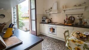 Une cuisine équipée d’un four à micro-ondes, d’un four traditionnel et de divers ustensiles de cuisine disposés sur le plan de travail.