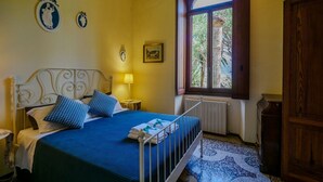 Une chambre à coucher avec un lit, une fenêtre, un radiateur et une porte en bois.