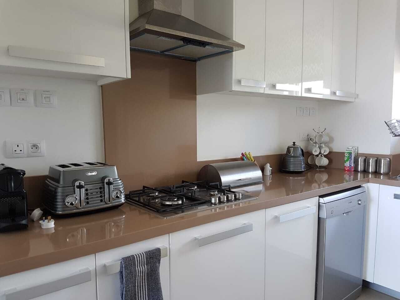 A modern kitchen with a gas stove, toaster, and stainless steel appliances.