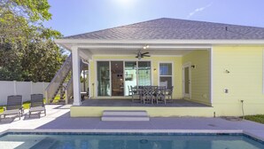 Una casa con piscina, un patio cubierto y una escalera que lleva al nivel superior.
