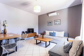 A modern living room with a sofa, coffee table, and a TV. - Villa Orchard - Four Bedroom Villa, Sleeps 9 (Zakynthos)