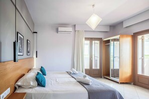 Una habitación de hotel moderna con cama, armario y puerta que da a un balcón.
