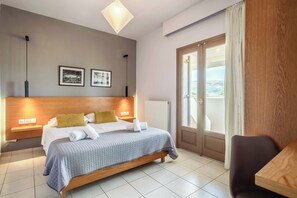 A modern hotel room with a bed, bedside tables, a desk, and a view of the outdoors. - Villa Orchard - Four Bedroom Villa, Sleeps 9 (Zakynthos)