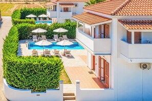 A residential property with a swimming pool, sun loungers, and a well-maintained garden. - Villa Orchard - Four Bedroom Villa, Sleeps 9 (Zakynthos)
