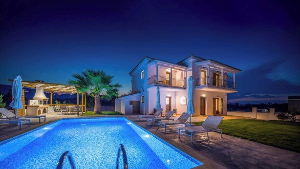 A two-story house with a swimming pool, outdoor seating, and a barbecue area.