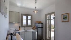 Una cocina moderna con un refrigerador de acero inoxidable, una cafetera y una ventana con vistas panorámicas.