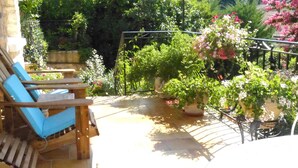 Une terrasse avec une chaise en bois et une plante en pot.