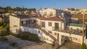 A residential building with a balcony, solar panels, and a staircase leading to the upper floor. - SAMAREITIDOS LIGHT STUDIO  - GREEN (Anafotia)