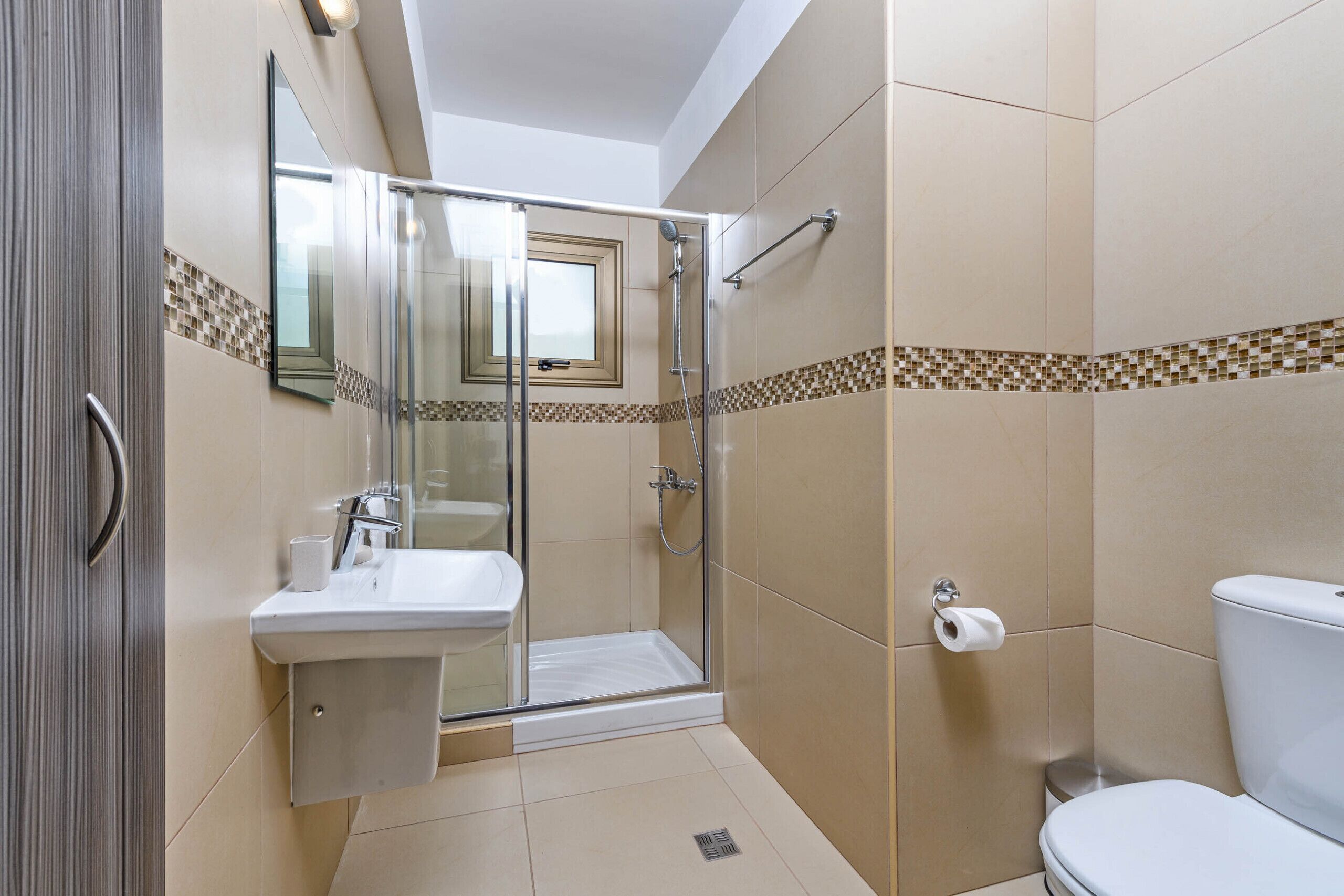 A modern bathroom with a glass-enclosed shower, a sink, and a toilet.