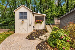 A two-story building with a garage, a front porch, and a small garden area with steps leading to the entrance. - The Oriole, hot tub, walk or Bike to Saugatuck! (Saugatuck)