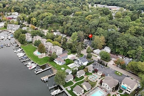 An aerial view of a residential area with houses, a marina, and a swimming pool.