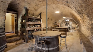 A rustic cellar bar with wooden barrels, a bar counter, and stools. - Il Giardino di Sibilla With Pool (Castelgomberto)