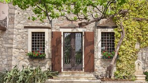 A stone building with a wooden door, two windows with metal grilles, and a small step leading to the entrance. - Il Giardino di Sibilla With Pool (Castelgomberto)