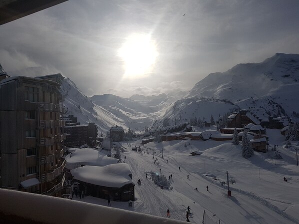 A snowy mountain town with buildings, ski slopes, and a sunlit sky. - Studio with mountain corner 1 (AVORIAZ)