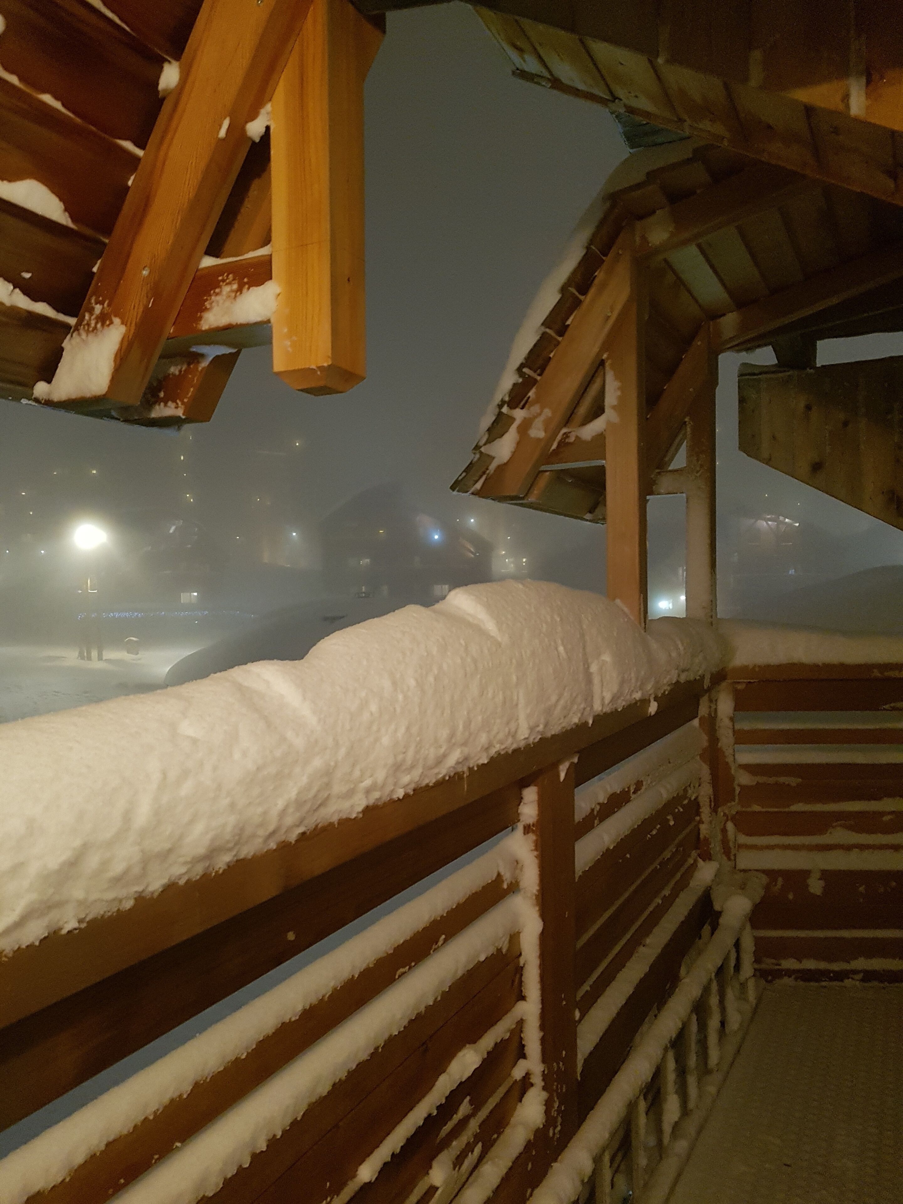 A wooden deck with snow accumulation.