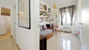 A bedroom with a bed, a chair, a desk, a wardrobe, a radiator, and a window with curtains. - Red House Rome - Trastevere (Roma)
