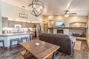 Enjoy cooking in the kitchen with a central island, refrigerator, and large flat-screen TV above the fireplace.
