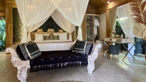 Amplia habitación con una cama grande bajo un dosel, un candelabro y una alfombra redonda.