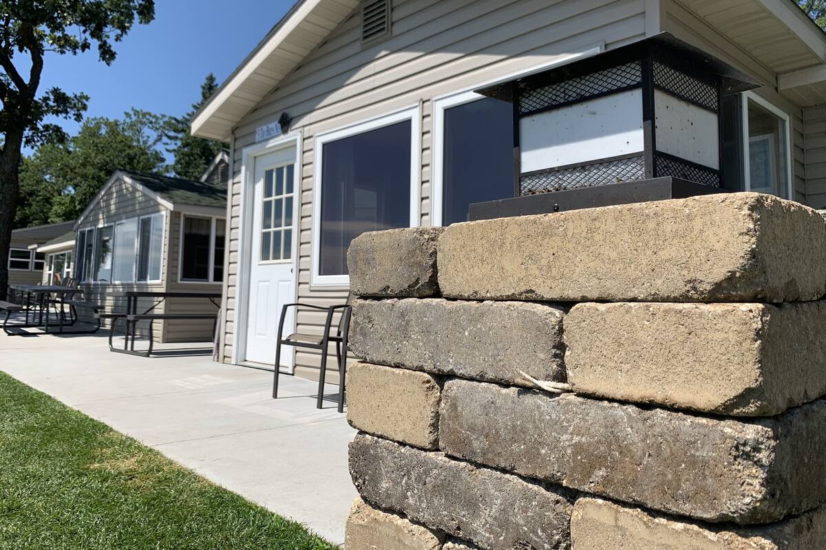 A building with a large window, a door, and a small porch area.