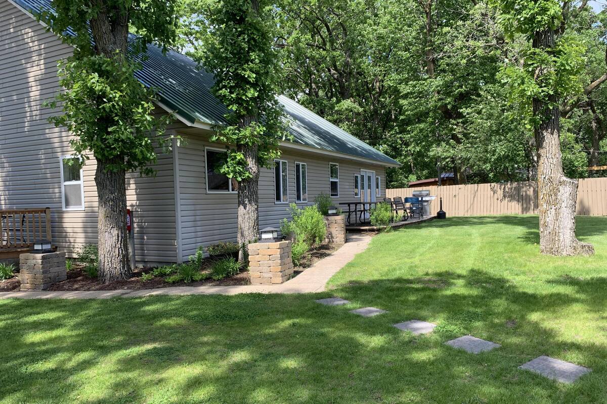 A single-story house with a covered patio, a brick pathway leading to the entrance, and a well-maintained lawn.