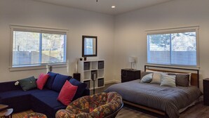 A bedroom with a bed, a sofa, a chair, a ceiling fan, and two windows with blinds. - Stylish, Salt Lake City, Home (Salt Lake City)