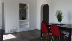 A modern room with a dark wooden desk, red chairs, a white shelving unit, and a potted plant. - Stylish, Salt Lake City, Home (Salt Lake City)