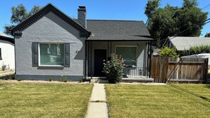 A residential house with a grey brick exterior, a front porch, and a well-maintained lawn. - Stylish, Salt Lake City, Home (Salt Lake City)