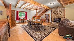 A cozy living room with a fireplace, a dining area with a wooden table and chairs, and a staircase leading to an upper level. - Fishing pond, 15 minutes to Nashville (Nashville)