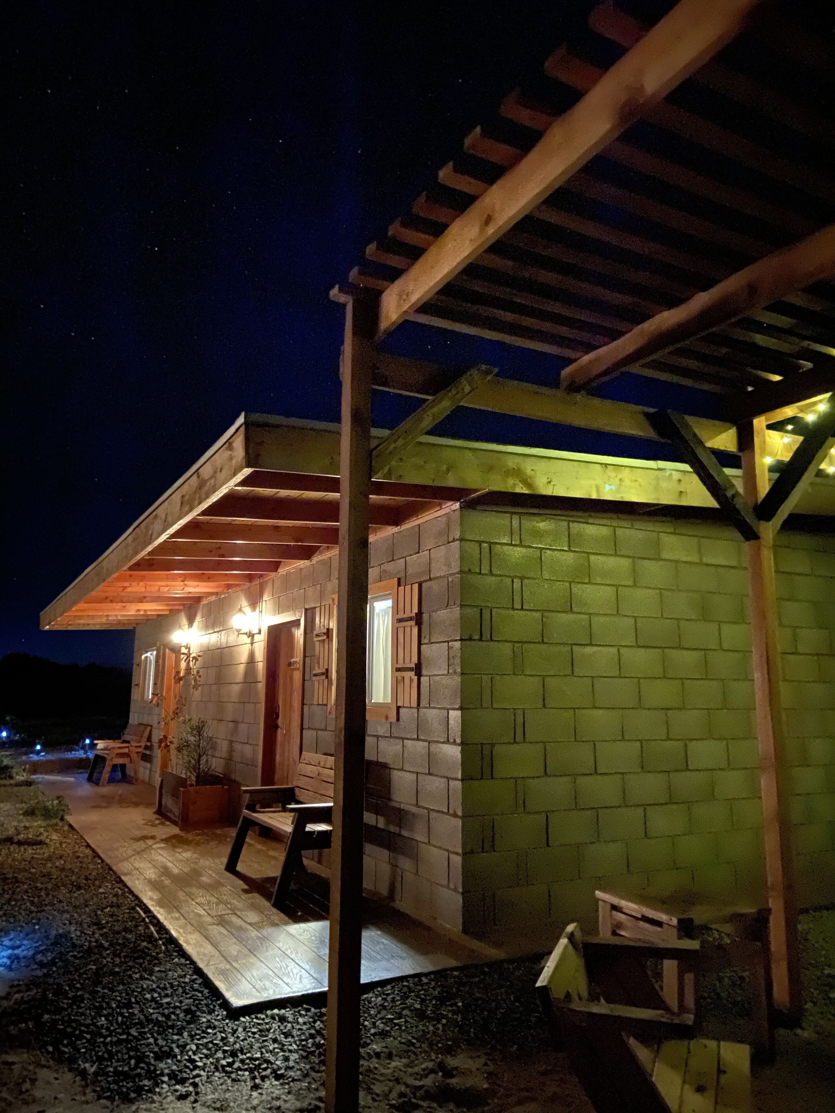 A small, single-story building with a wooden porch and a covered area.