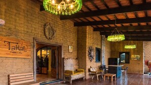 A rustic interior with exposed brick walls, wooden benches, and green bottle chandeliers. - Sn Tony Hotel & Spa (Valle de Guadalupe)