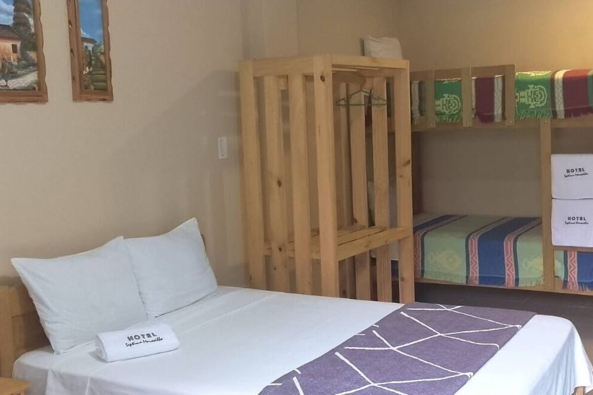Ein Hotelzimmer mit einem Einzelbett, einem Holzbett und einem Kleiderschrank.