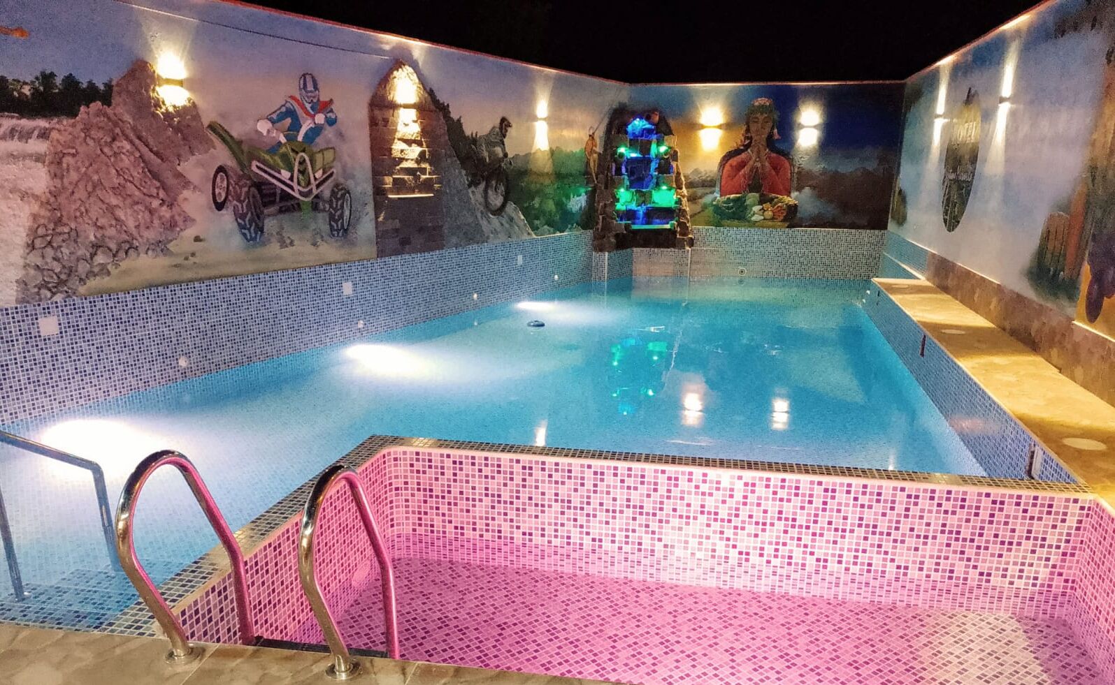 A swimming pool with mosaic tiling and a mural depicting various scenes.