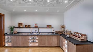 Una cucina moderna con mobili in legno, un piano di lavoro nero e diversi prodotti alimentari esposti.