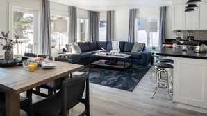 Una cocina moderna con comedor, una sala de estar con sofá y una zona de bar.