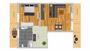 Plano de una habitación de hotel con cama, un baño pequeño, zona de estar con sofá y mesa de centro, y comedor con mesa y sillas.