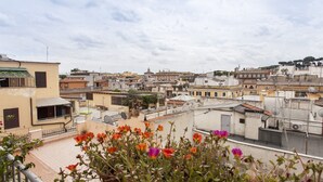 A rooftop terrace with potted flowers, a cityscape in the background, and a clear sky. - Holiday home 'Suite Sarandrea' in Rome in the Vatican area of San Pietro (Roma)