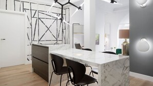 A modern kitchen with a marble island, black chairs, and pendant lighting. - Moraza Suite by FeelFree Rentals (San Sebastián)