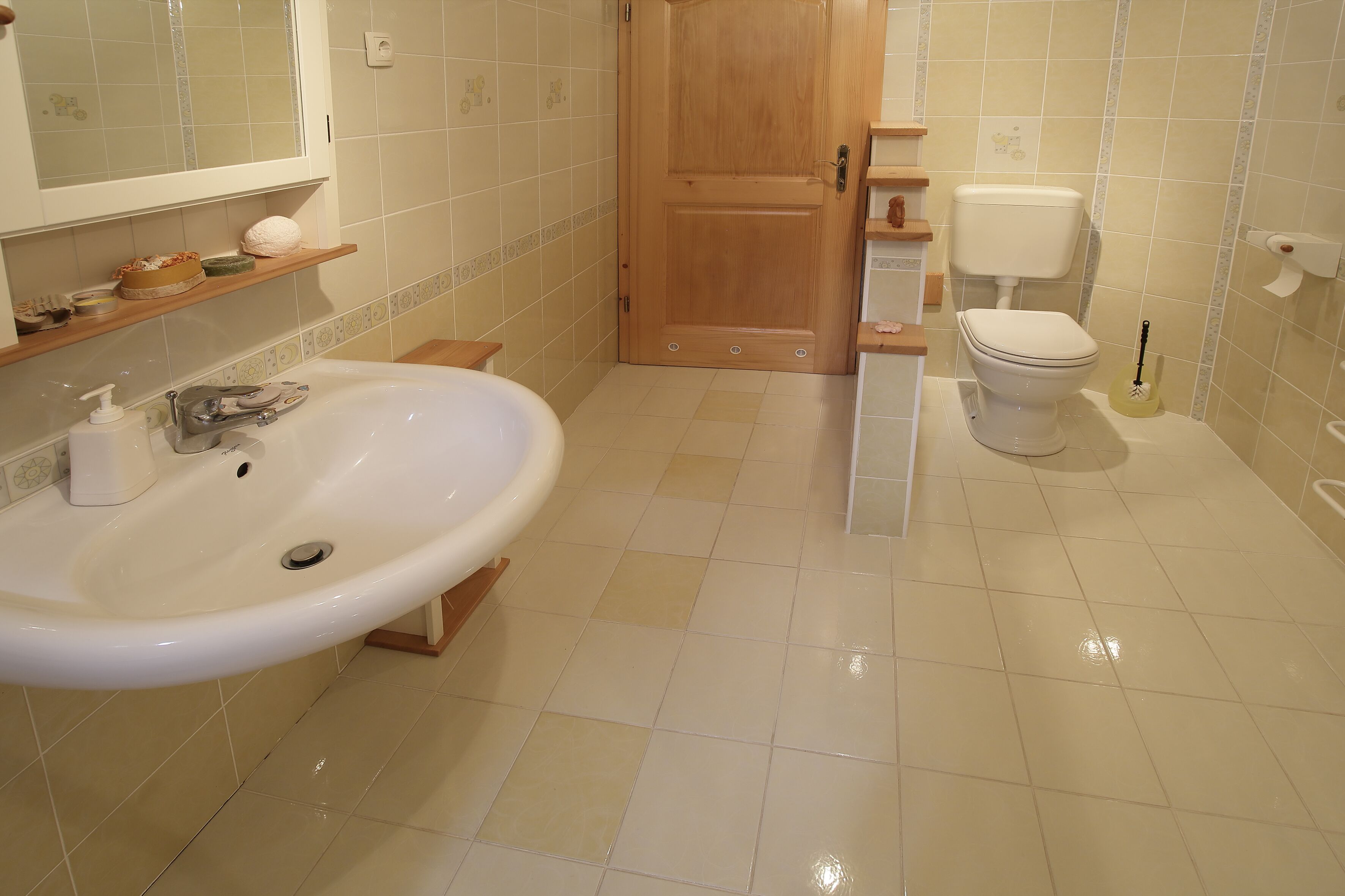 A bathroom with a sink, toilet, and wooden door.