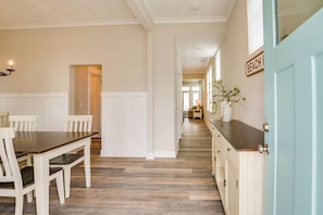 Enjoy meals in this kitchen with a long countertop and dining table for four, adjacent to a living area.