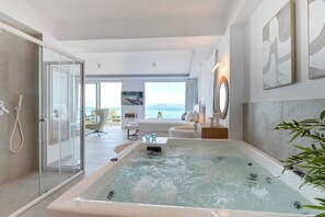 Een bad/douchecombinatie, een bubbelbad, een haardroger, handdoeken