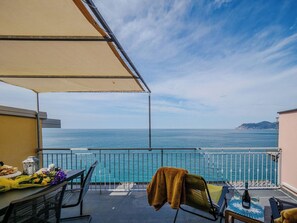 A balcony with a table, chairs, and a view of the sea. - La Lampara Sea View Terrace Apartment with AC (Manarola)